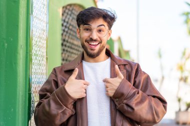 Dışarıdaki yakışıklı Arap 'ın yüzünde sürpriz bir ifade var.