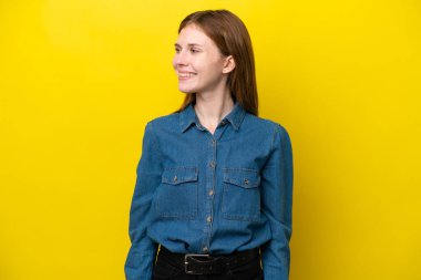 Sarı arka planda izole edilmiş genç bir İngiliz kadın.