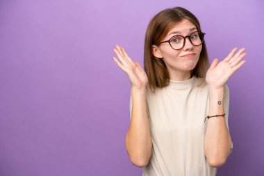 Mor arka planda izole edilmiş genç bir İngiliz kadın şüpheli hareketler yapıyor.