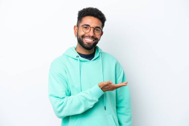 Genç Brezilyalı bir adam beyaz arka planda izole edilmiş bir fikir sunuyor.