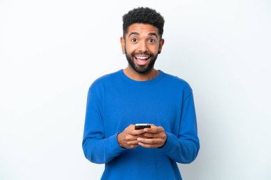 Beyaz arka planda izole edilmiş genç Brezilyalı bir adam şaşırdı ve bir mesaj gönderiyor.