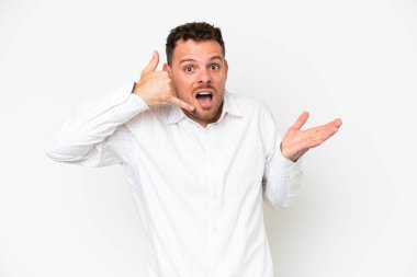 Beyaz arka planda izole edilmiş beyaz tenli yakışıklı bir adam telefon jesti yapıyor ve şüpheli.