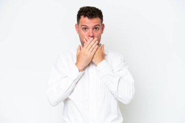 Beyaz arka planda izole edilmiş beyaz tenli yakışıklı bir adam elleriyle ağzını kapatıyor.