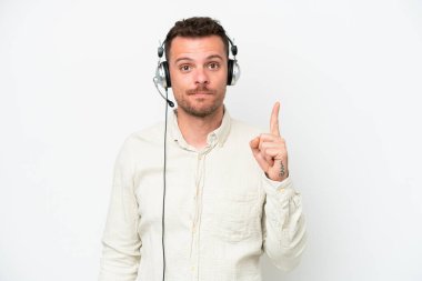 Beyaz arka planda izole edilmiş kulaklıkla çalışan beyaz pazarlamacı beyaz adam işaret parmağıyla işaret etmek harika bir fikir.