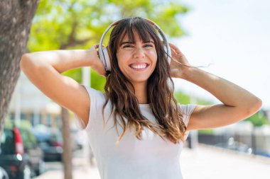 Açık havada müzik dinleyen genç bir kadın