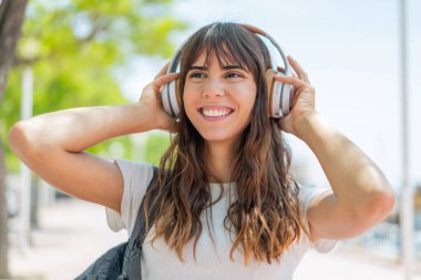 Açık havada müzik dinleyen genç bir kadın