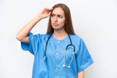 Beyaz arka planda fazla izole olmuş genç hemşire kadının şüpheleri var ve kafası karışmış bir yüz ifadesi var.