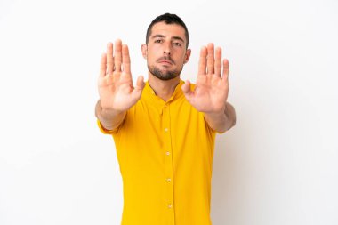 Beyaz arka planda izole edilmiş yakışıklı beyaz adam dur hareketi yapıyor ve hayal kırıklığına uğruyor.