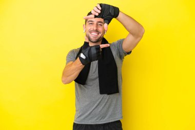 Sarı arka planda izole edilmiş, odaklanan genç beyaz bir adam. Çerçeve sembolü