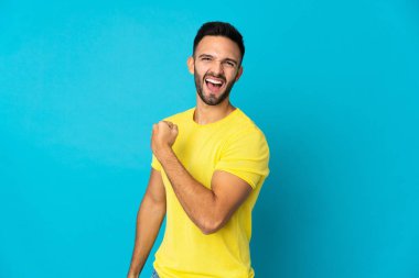 Mavi arka planda izole edilmiş beyaz bir adam zaferi kutluyor.