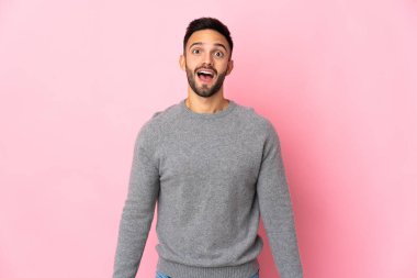 Pembe arka planda yalıtılmış beyaz bir adam. Şaşırtıcı bir yüz ifadesi var.