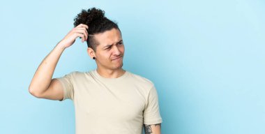 Kafkasyalı bir adam izole edilmiş arka planda, kafası kaşınırken şüpheleri var.