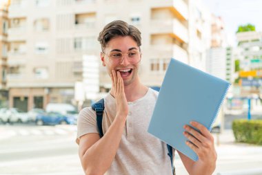 Dışarıdaki yakışıklı öğrenci şaşırmış ve şok olmuş bir yüz ifadesiyle.
