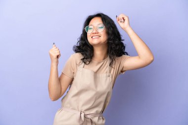 Restoran Asyalı garson mor arka planda izole edilmiş bir şekilde zaferi kutluyor.