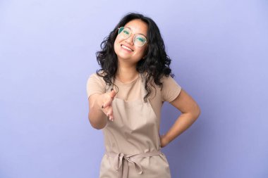 Restoran Asyalı garson, mor arka planda izole edilmiş, iyi bir anlaşma için el sıkışıyor.