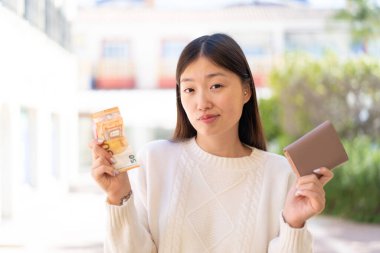 Parası olan ve kuşkuları olan güzel bir Çinli kadın.