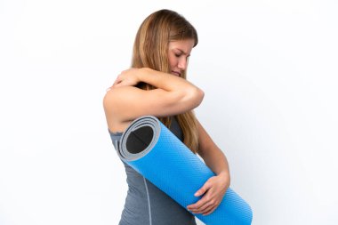 Genç sporcu kadın yoga derslerine giderken omzunda acıdan muzdarip bir minder tutuyor.