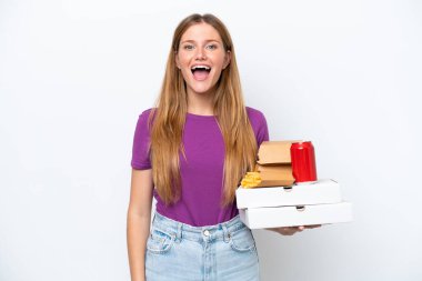 Beyaz arka planda, yüzünde sürpriz bir ifadeyle hazır yemek tutan güzel sarışın kadın.