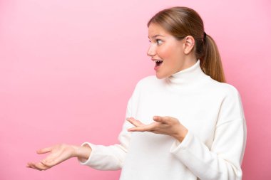 Pembe arka planda mahsur kalmış beyaz bir kadın. Sürpriz bir ifadeyle yan yana bakarken.