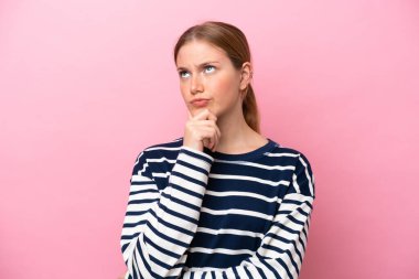 Pembe arka planda izole edilmiş beyaz bir kadın. Şüpheleri var.