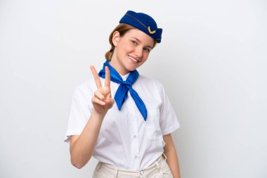 Beyaz arka planda izole edilmiş uçak hostesi kadın gülümsüyor ve zafer işareti gösteriyor.