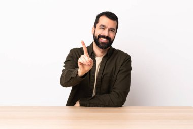 Masada sakallı, beyaz bir adam parmağını kaldırıyor..