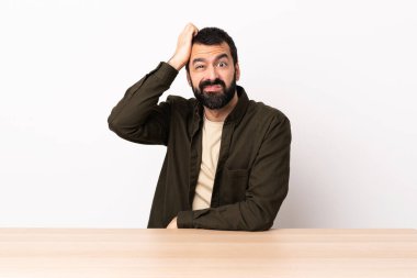 Masada sakallı, hayal kırıklığı ifadesi olan ve anlamayan beyaz bir adam..