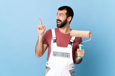 Yetişkin ressam, izole edilmiş mavi arkaplanda parmağını kaldırırken çözümü bulmayı umuyor.