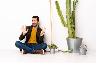 Bahçıvan içeride yerde oturmuş parmaklarıyla sekizi sayıyor.