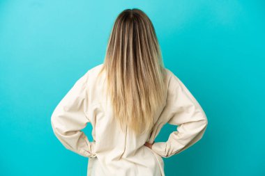 Arka planda soyutlanmış mavi arka planda genç bir kadın var.