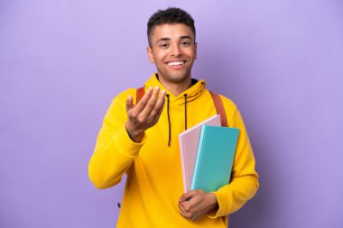 Mor arka planda izole edilmiş Brezilyalı genç bir adam, bizimle gelmesi için davet ediyor. Gelmene sevindim.