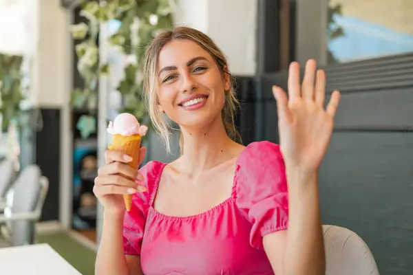 Young Blonde Woman Cornet Ice Cream Outdoors Saluting Hand Happy — Stock Photo, Image