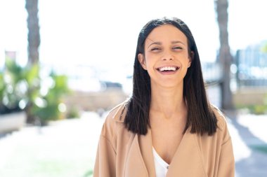 Açık havada genç bir kadın Neşeli bir ifadeyle