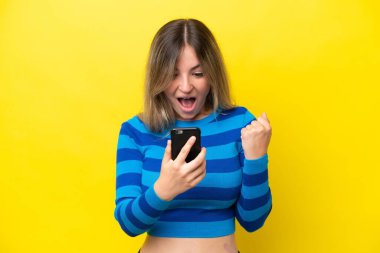 Sarı arka planda izole edilmiş genç Romen kadın şaşırdı ve bir mesaj gönderiyor