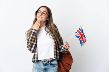 Beyaz arka planda izole edilmiş bir Birleşik Krallık bayrağı taşıyan genç Romen kadın gülümserken yukarı bakıyor