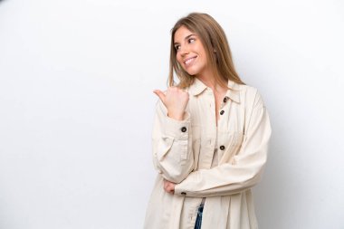 Young caucasian woman isolated on white bakcground pointing to the side to present a product