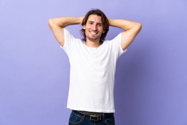 Mor arka planda yalnız, yakışıklı bir adam gülüyor.