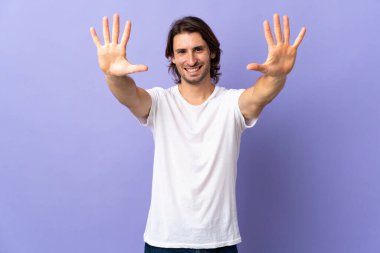 Mor arka planda izole edilmiş genç ve yakışıklı bir adam.