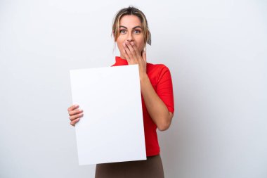 Beyaz arka planda izole edilmiş beyaz bir kadın elinde şaşırmış bir ifadeyle boş bir levha tutuyor.