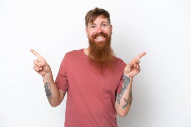 Kızıl saçlı uzun sakallı adam beyaz arka planda izole edilmiş, parmak uçlarını işaret ediyor ve mutlu.