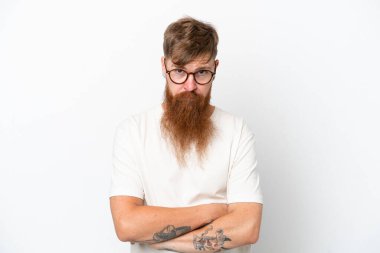 Uzun sakallı kızıl saçlı adam üzgün bir ifadeyle beyaz arka planda izole edilmiş.