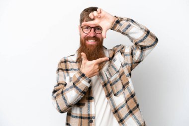 Kızıl saçlı, uzun sakallı, beyaz arka planda, odaklanan yüzü olan bir adam. Çerçeve sembolü