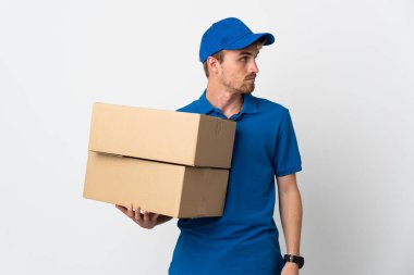 Beyaz arka planda izole edilmiş genç, sarışın adam yan tarafa bakıyor.