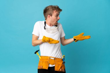 Suratı şaşırmış genç elektrikçi duvarın üstünde.