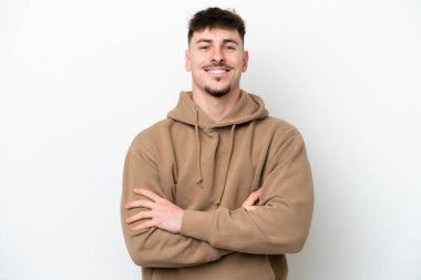 Young caucasian handsome man isolated on white background keeping the arms crossed in frontal position