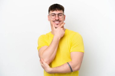 Beyaz arka planda yalnız, mutlu ve gülümseyen beyaz yakışıklı bir adam.