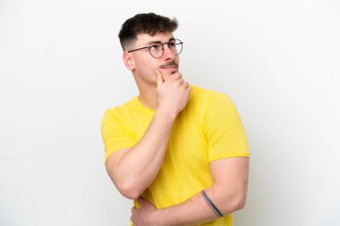 Beyaz arka planda izole edilmiş beyaz tenli yakışıklı bir adam yukarı bakarken bir fikir düşünüyor.