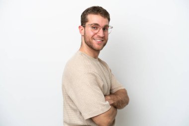 Beyaz arka planda izole edilmiş, kolları çapraz ve ileriye bakan genç beyaz bir adam.