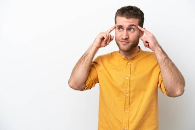 Beyaz arka planda soyutlanmış genç beyaz bir adamın şüpheleri ve düşünceleri var.