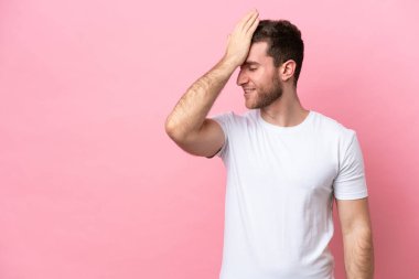 Pembe arka planda izole edilmiş genç beyaz adam bir şey fark etti ve çözüme niyetlendi.